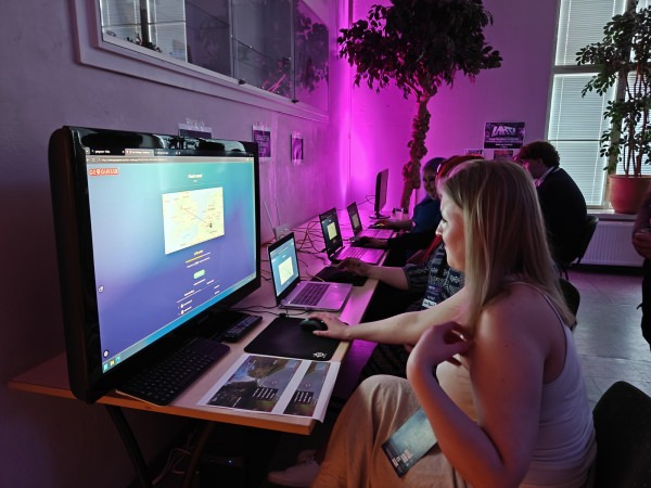 Laajempi kuva GeoGuessr-pisteestä Restomeet 2026 -tapahtumassa, useita pelaajia näytöillä