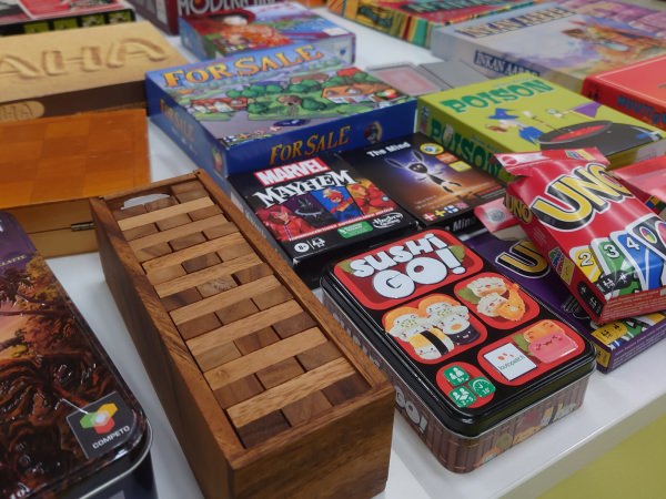 Different board games, including Sushi Go!, Jenga, The Mind, Uno, Marvel Mayhem, For Sale, at Kaptam Gamers Lahti Game Night Board Games