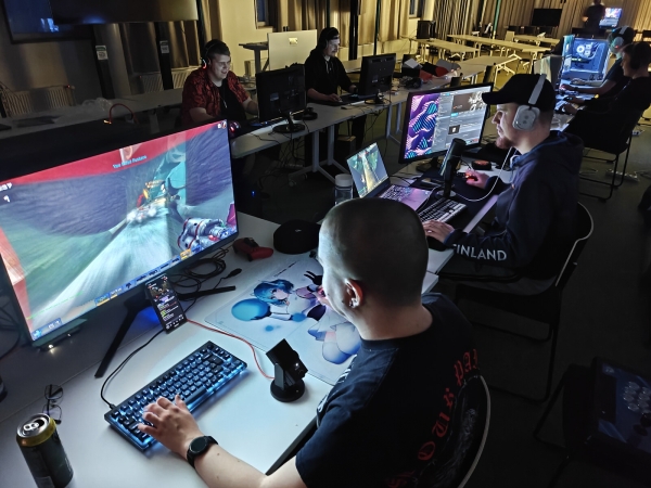 Juuso, Funz, Spades ja Marko pelaamassa UT2004 deathmatchia Lahti LAN Party 2026 -tapahtumassa Pöllö-auditoriossa
