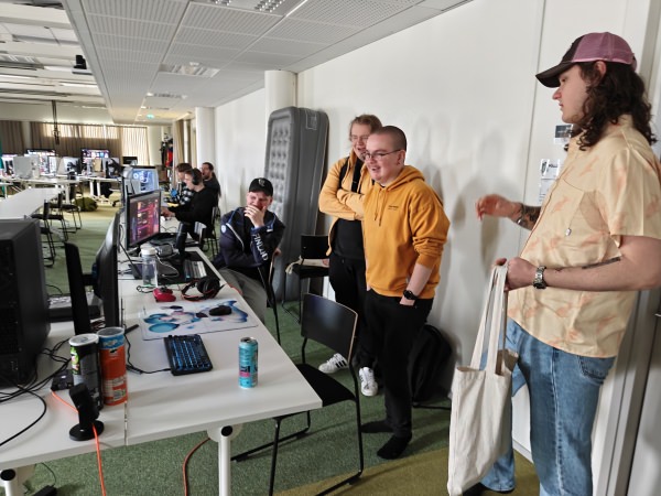 LahtiFGC-porukkaa hymyilemässä ja nauramassa Lahti LAN Party 2026 -tapahtumassa Pöllö-auditoriossa päiväsaikaan